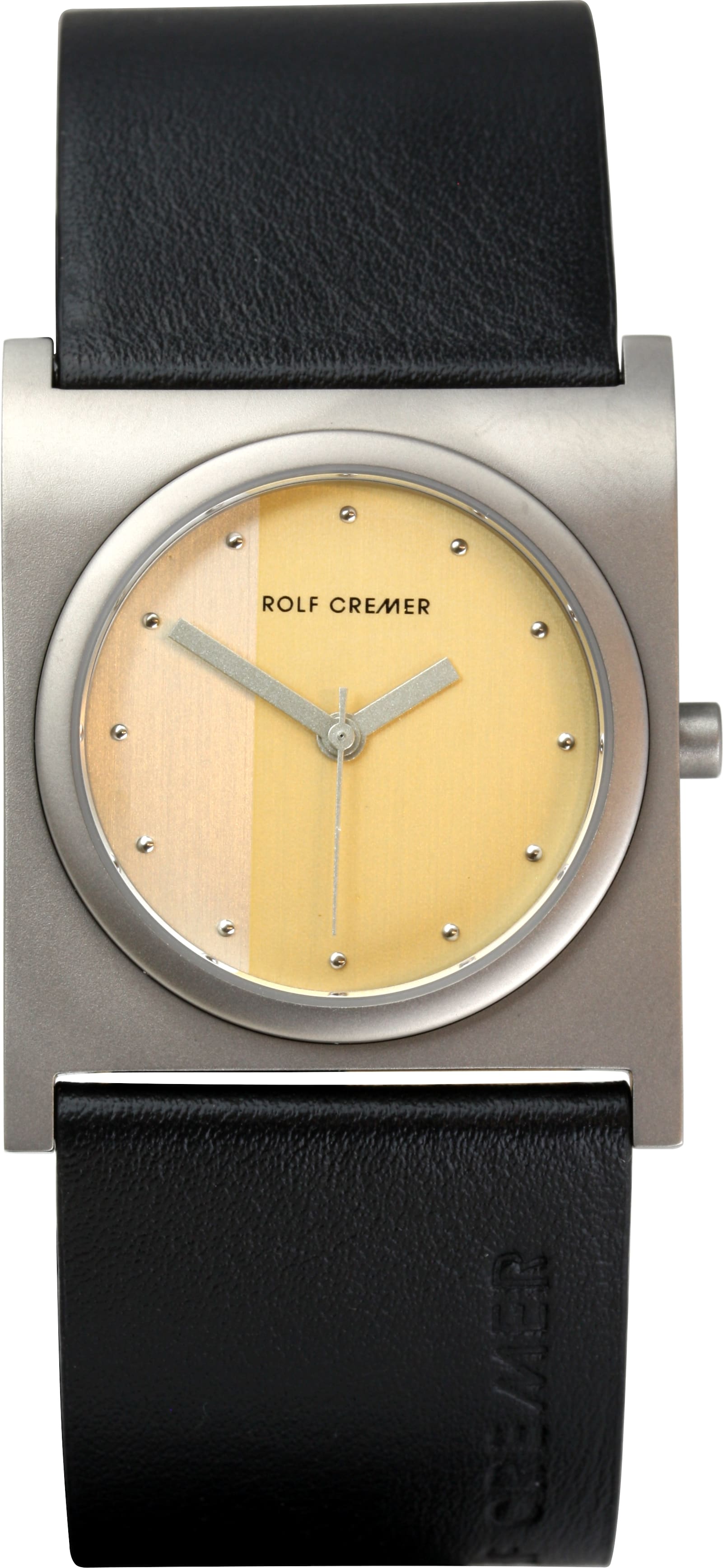 Rolf Cremer horloge met vierkante titanium kast, warm gouden wijzerplaat en zwarte band.